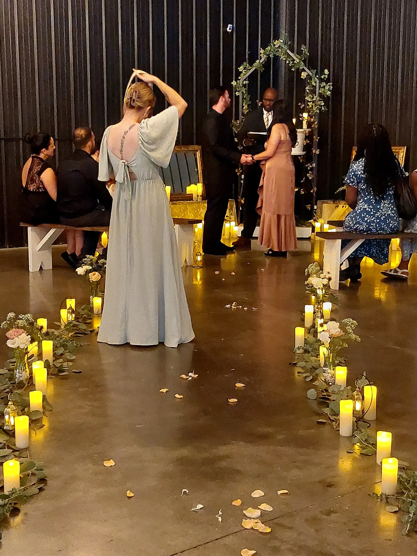 A wedding ceremony with the couple, officiant and guests inside The Dallas Markets event venue